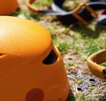 closeup of orange climbing helmet and harnesses