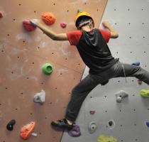 boy climbing n bouldering wall