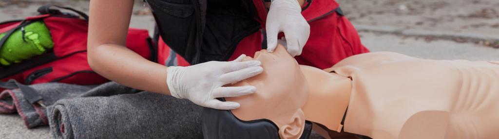 person preparing to give CPR on a dummy