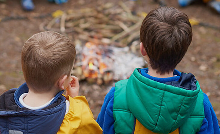 young boys in front of campfire