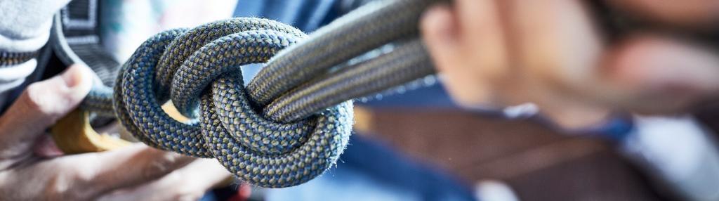 hands holding climbing rope with knot