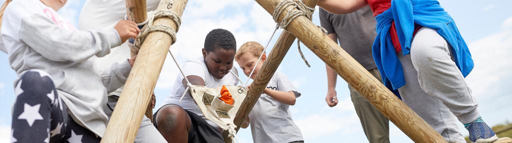 children building a large wooden ballista with poles and ropes