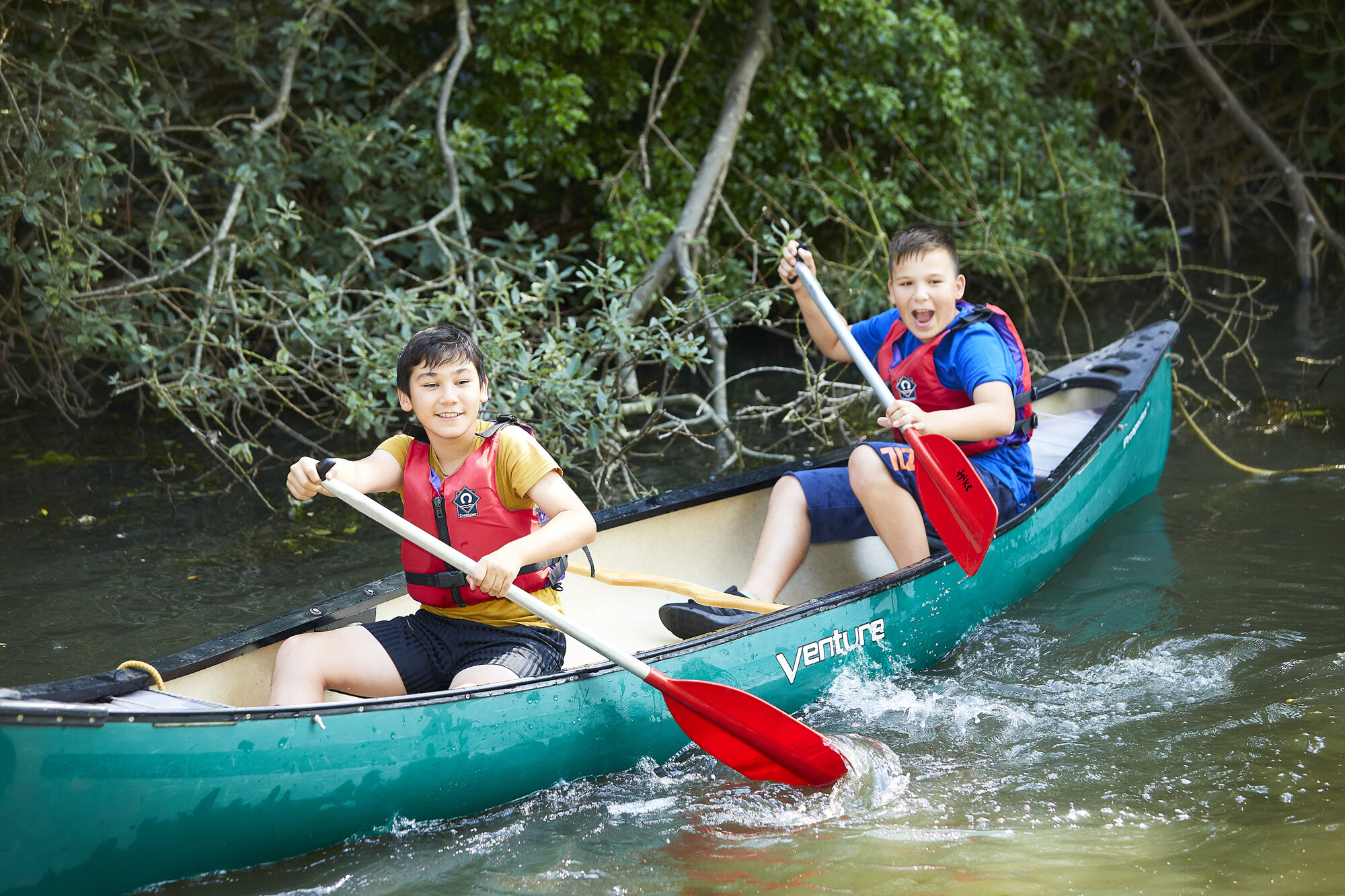 two smiling boys in a canoe